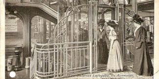 Galeries Lafayette, Parigi. Interno dei grandi magazzini con clienti dell’epoca di fronte all’ascensore in stile Art Nouveau integrato nella scalinata. Cartolina d’epoca.