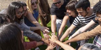 Studenti del Master Cooperation and Development in cerchio mentre uniscono le mani