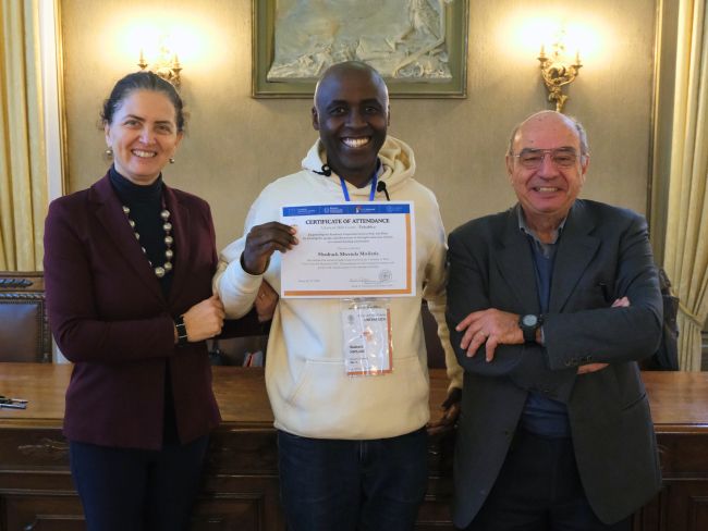 Shadrack Mwilari from Kenyatta University receive his certificate of attendance at the end of the staff week